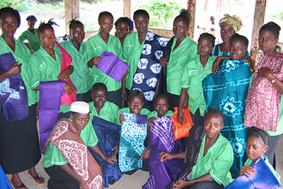 Women display tie-and-dye products made by their group